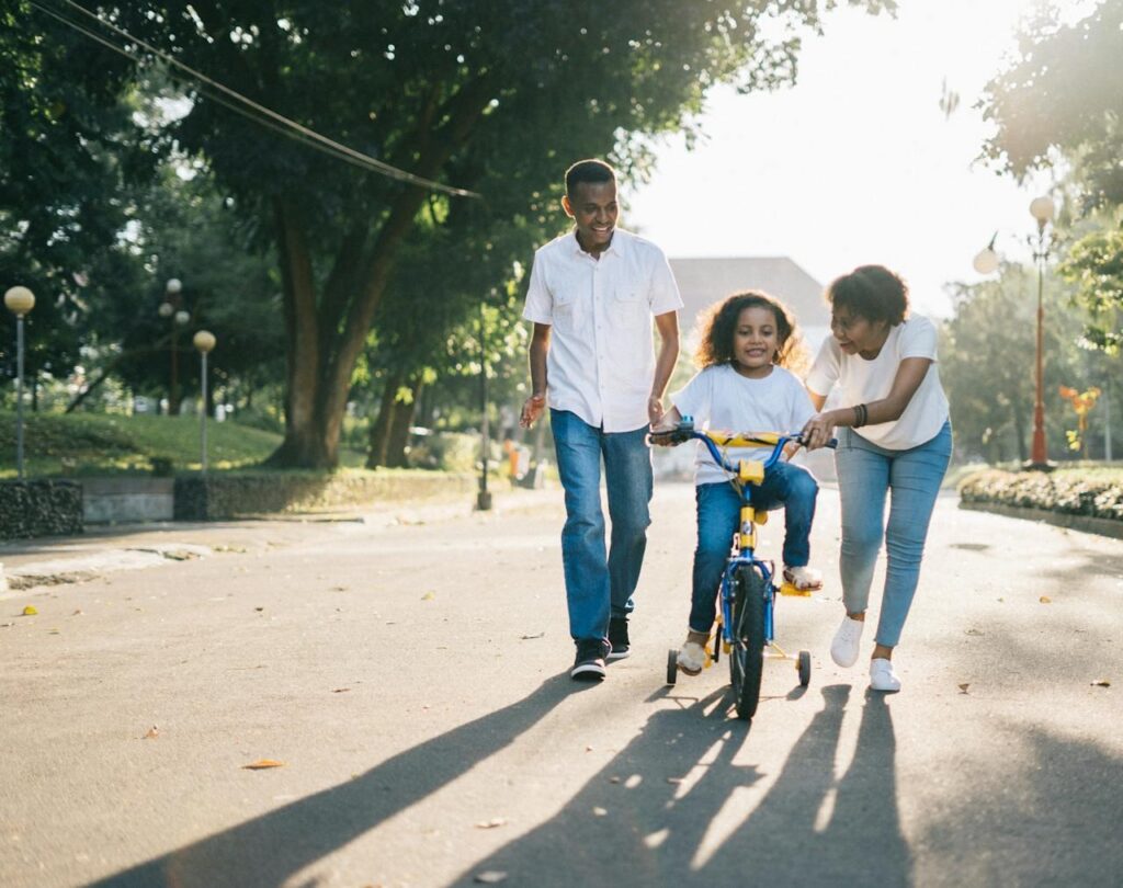 a family living in Denver, teaching a kid how to ride a bike